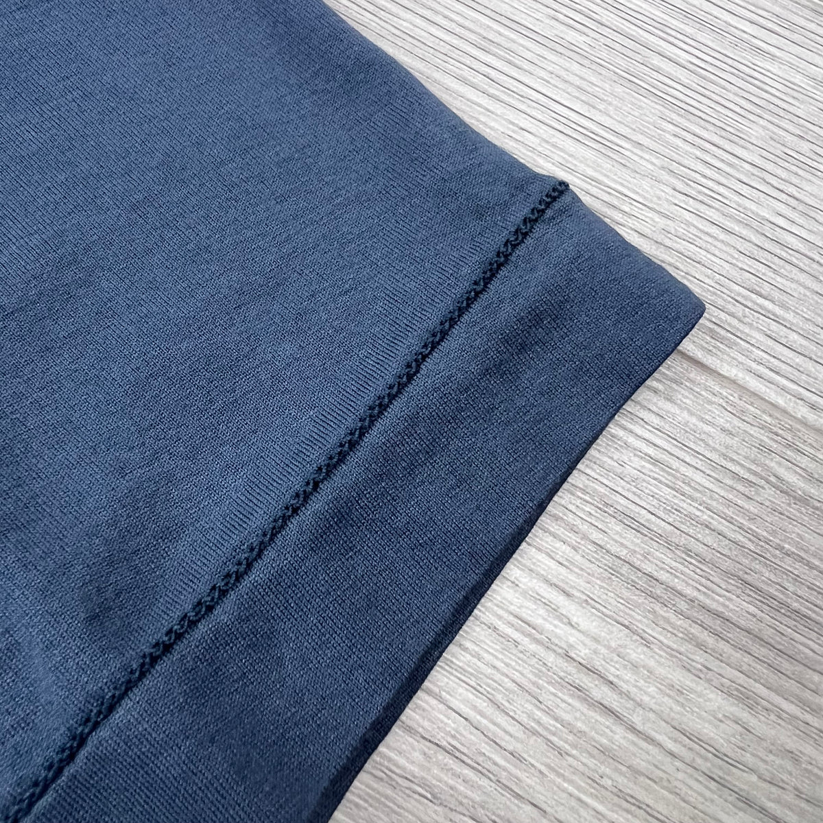 Front view of the chain stitching on the hem of a Stone Island 30/1 Patch T-Shirt in Slate Blue.