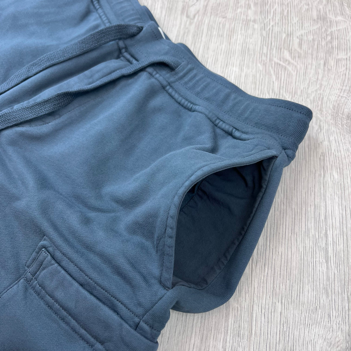 A close up view of the hand pockets on the Stone Island Jersey Shorts in Slate Blue.