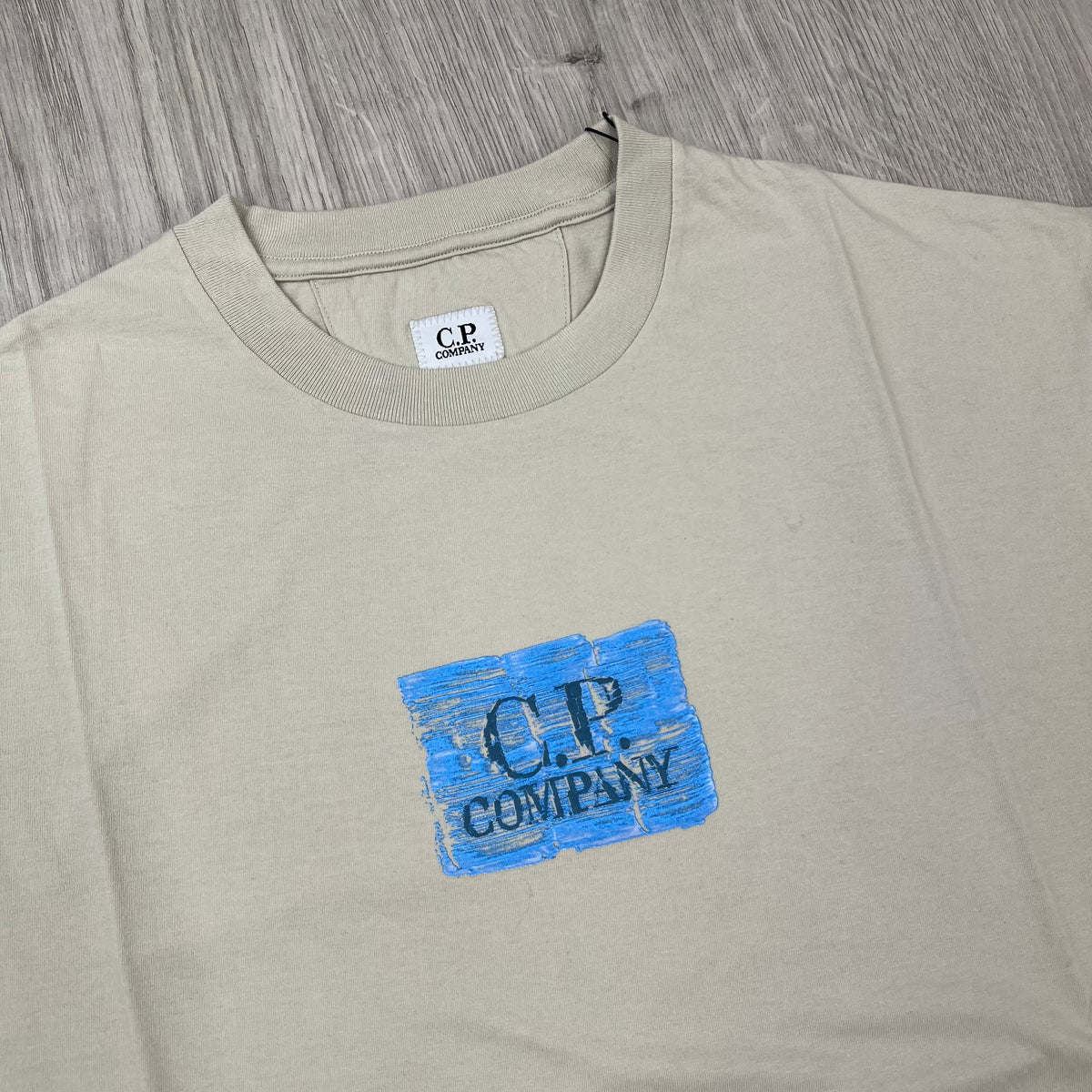 Close up view of the crewneck collar on a CP Company 30/1 Jersey Graphics T-Shirt in Silver Birch. 