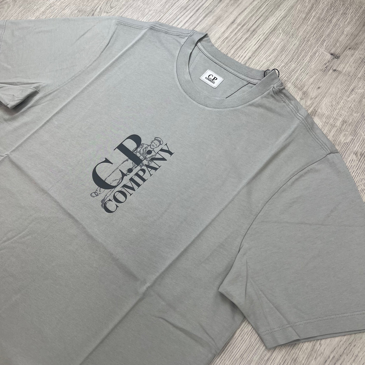 Angled view of a CP Company 30/1 Sailor T-Shirt in Flint Grey. 