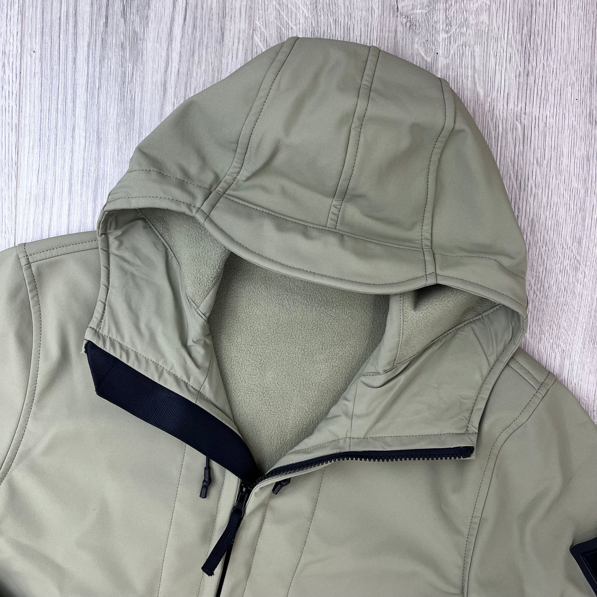 A close up view of the hood on a Stone Island Soft Shell-R_e.dye® Jacket in Laurel Green.